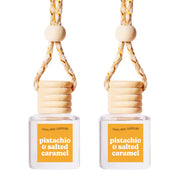 Cool Girl Candles hanging bottle front showing pistachio salted caramel scent and compact design benefit