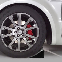 Fasmov chock in use against trailer tire preventing roll during hitching benefit