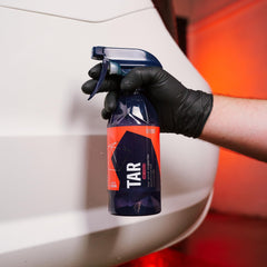Gyeon tar remover being sprayed on car panel for fast tar breakdown