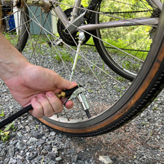 LockNFlate close-up of six steel jaws gripping a Schrader valve for secure hands-free inflation