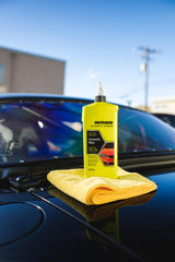 Applying Mothers hybrid ceramic wax to a car hood with applicator demonstrating simple wax-on wax-off use