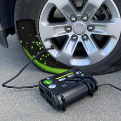 Slime inflator plugged into car 12V socket powering a quick one-person repair benefit