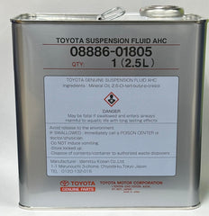 Toyota genuine suspension fluid being poured beside a measured container to ensure correct service volume