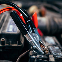 ABN clamps attached to car battery terminals demonstrating safe, firm connection
