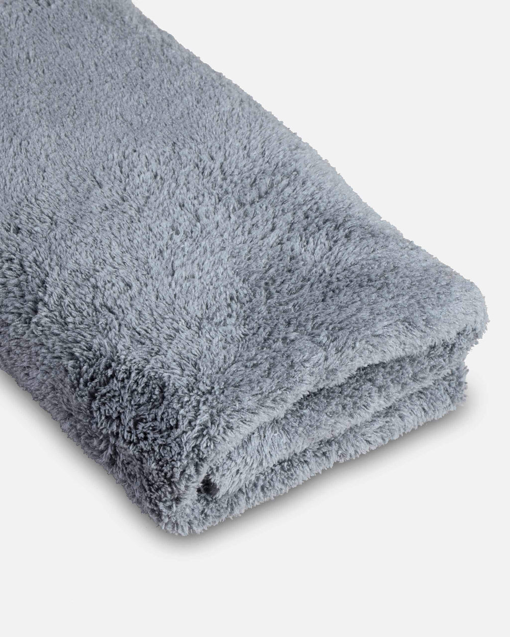 Adam's Polishes towel beside hand and ruler showing compact 16x16 size usefulness