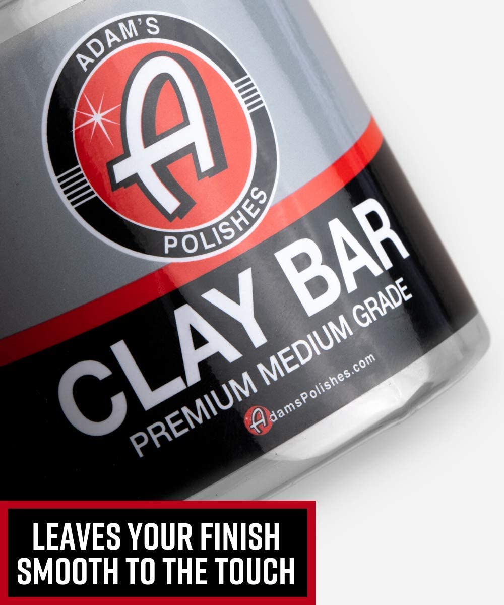 Adam's Polishes clay kit staged with a car demonstrating professional finish preparation