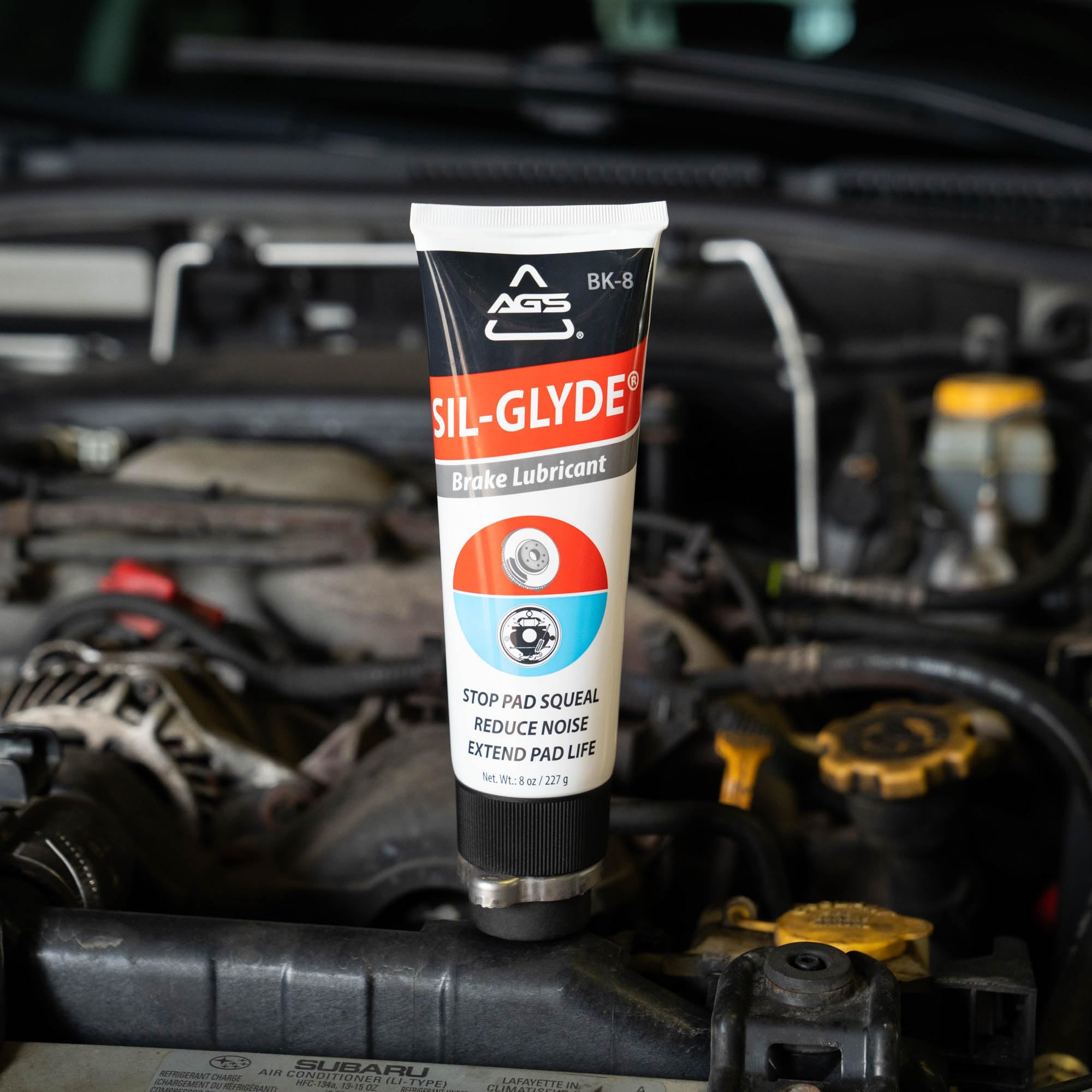 AGS SIL-Glyde tube in hand displaying 8 oz scale for easy storage and application