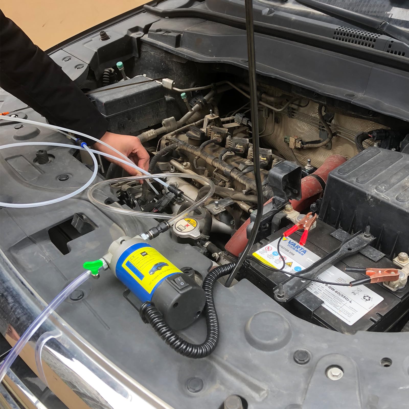AIGMlSON next to a car battery for scale showing portable 12V battery operation