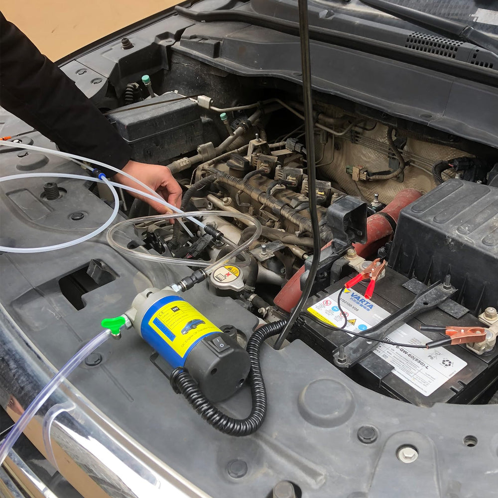 AIGMlSON next to a car battery for scale showing portable 12V battery operation