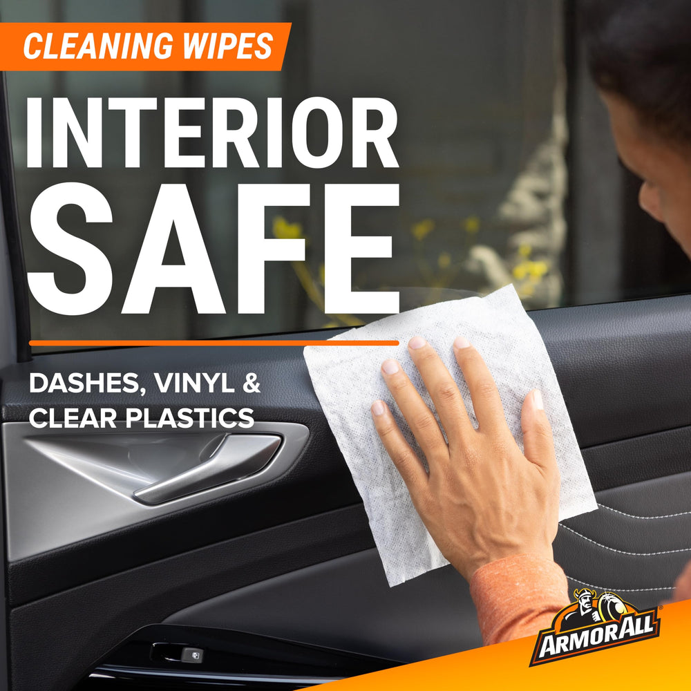Using an Armor All cleaning wipe on a dashboard to remove dust quickly