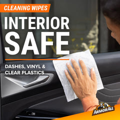 Using an Armor All cleaning wipe on a dashboard to remove dust quickly