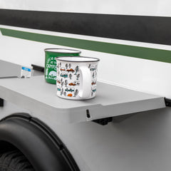 Camco table attached to RV rail demonstrating quick mount and space-saving benefit