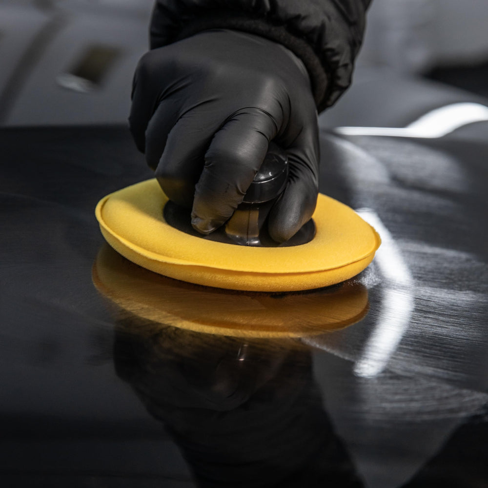 Car Gods hand applying wax to hood demonstrating easy use
