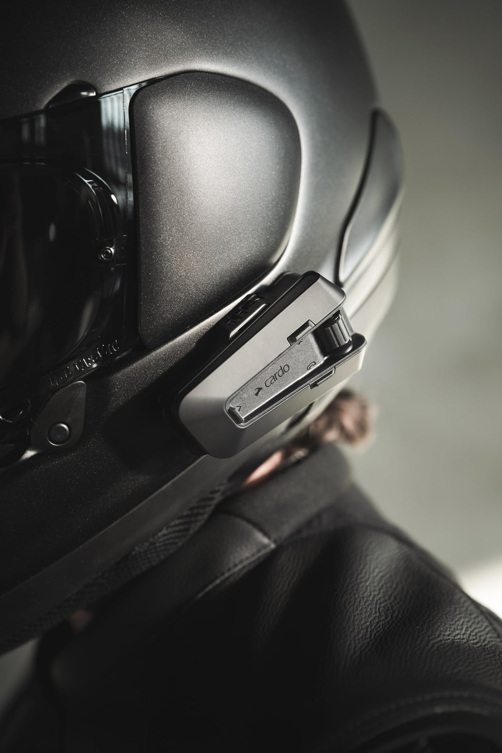 Cardo PACKTALK PRO mounted on helmet illustrating hands-free communication while riding safely