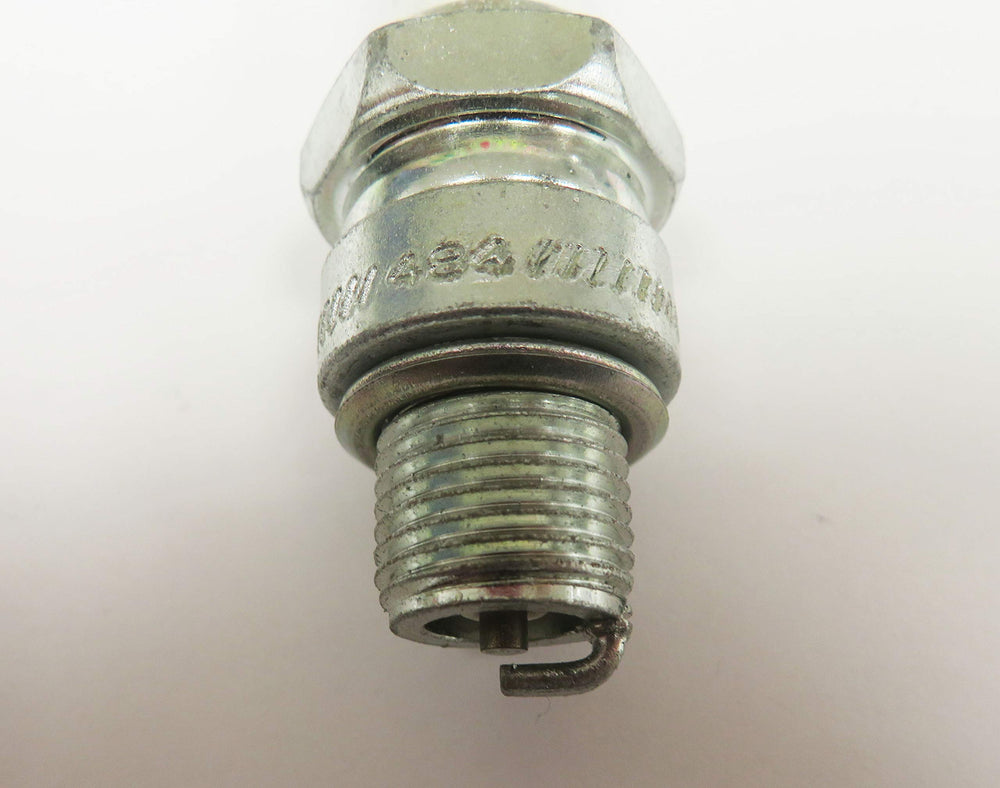 Champion spark plug beside 21mm socket illustrating hex size and installation scale