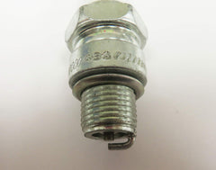Champion spark plug beside 21mm socket illustrating hex size and installation scale