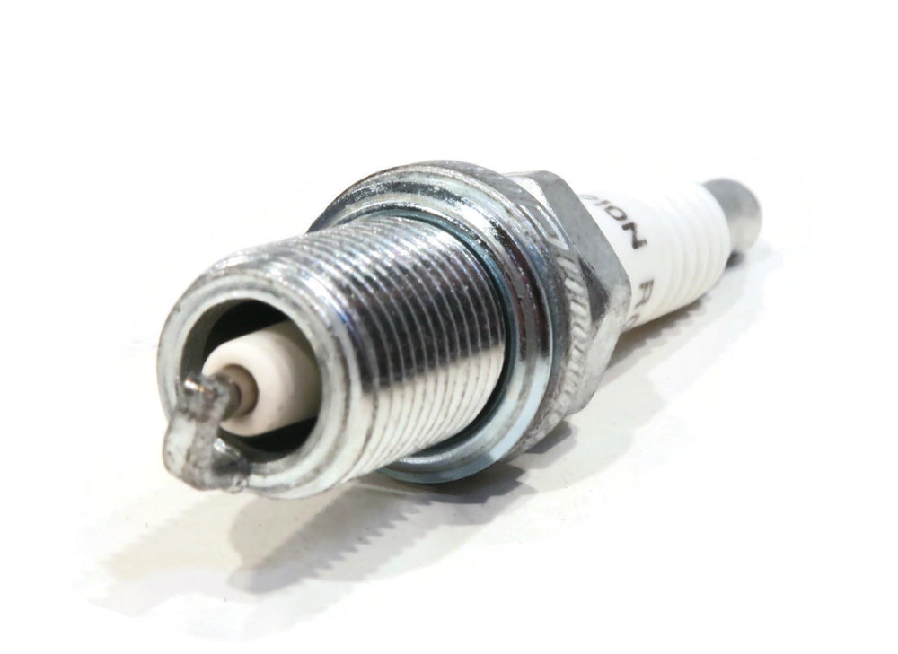 Champion RC12YC installed in a lawnmower spark plug well for reliable starts