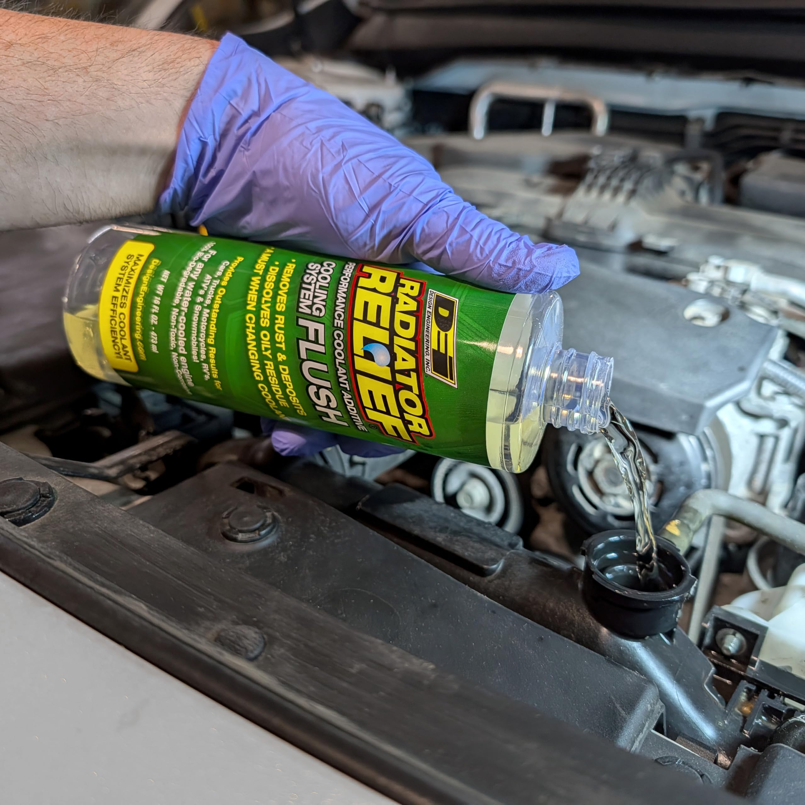 Design Engineering bottle placed under car hood ready for maintenance