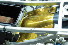 Design Engineering Reflect-A-Gold adhesive back exposed showing strong bond to surfaces