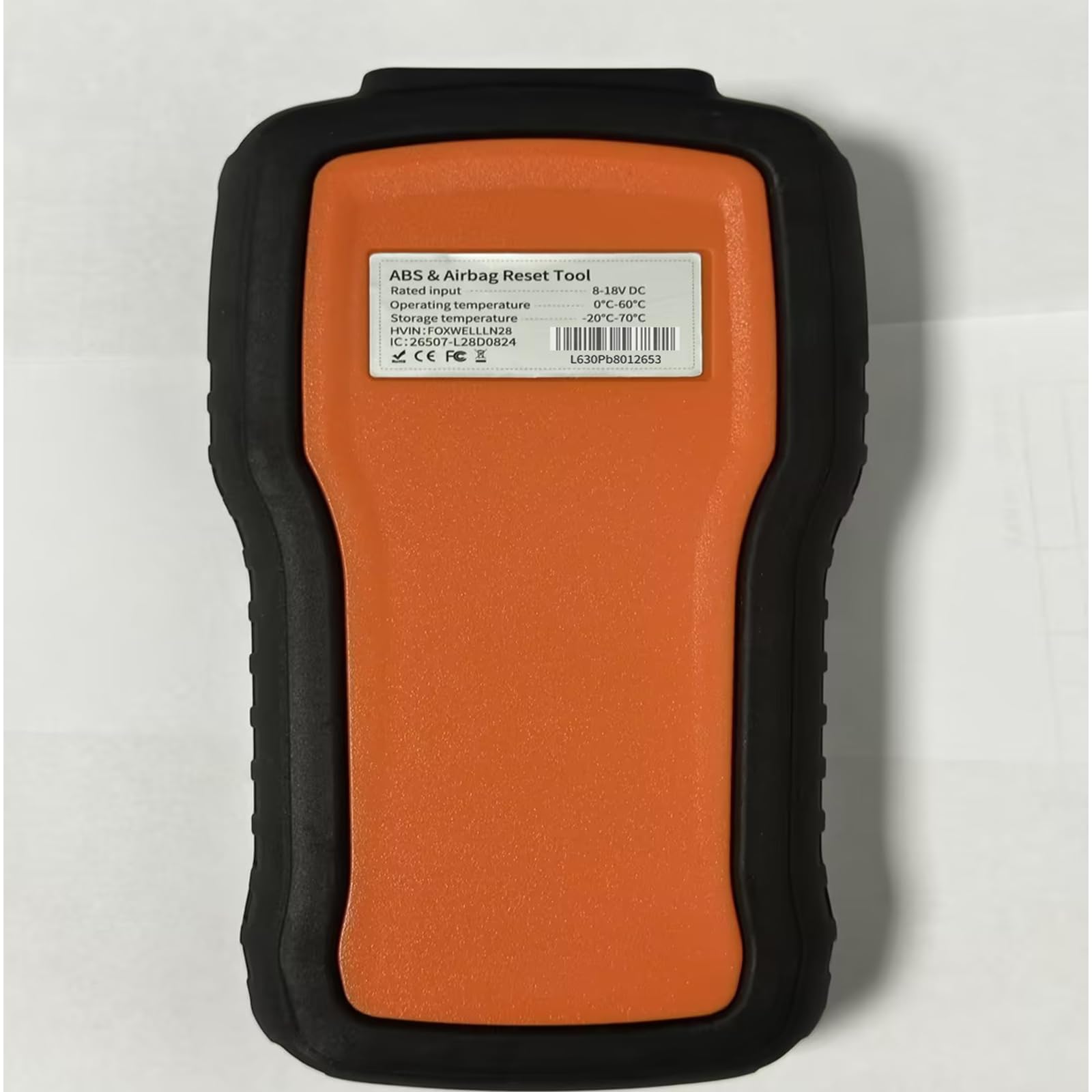 FOXWELL NT630 Plus in a garage setting next to tools, ideal for DIY mechanics