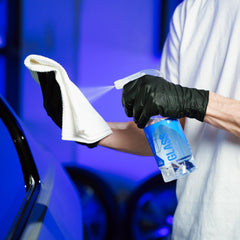Gyeon with microfiber wiping glass for streak-free clarity