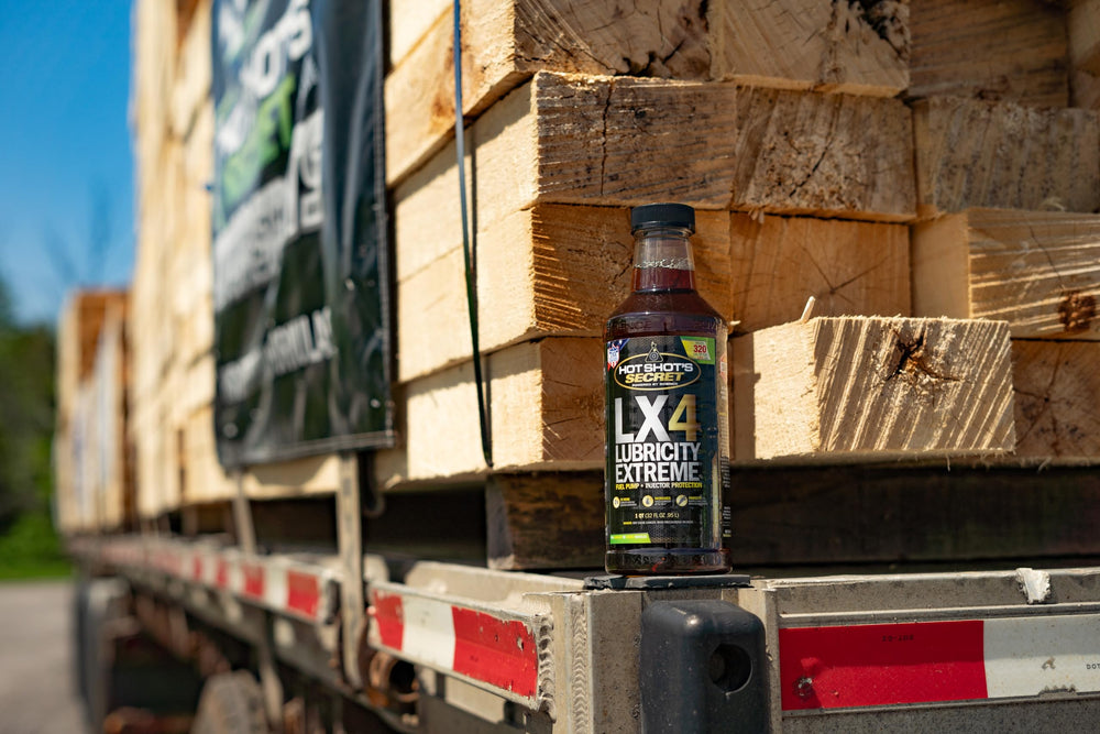 Hot Shot's Secret LX4 bottle beside a gasoline can showing correct dosing scale