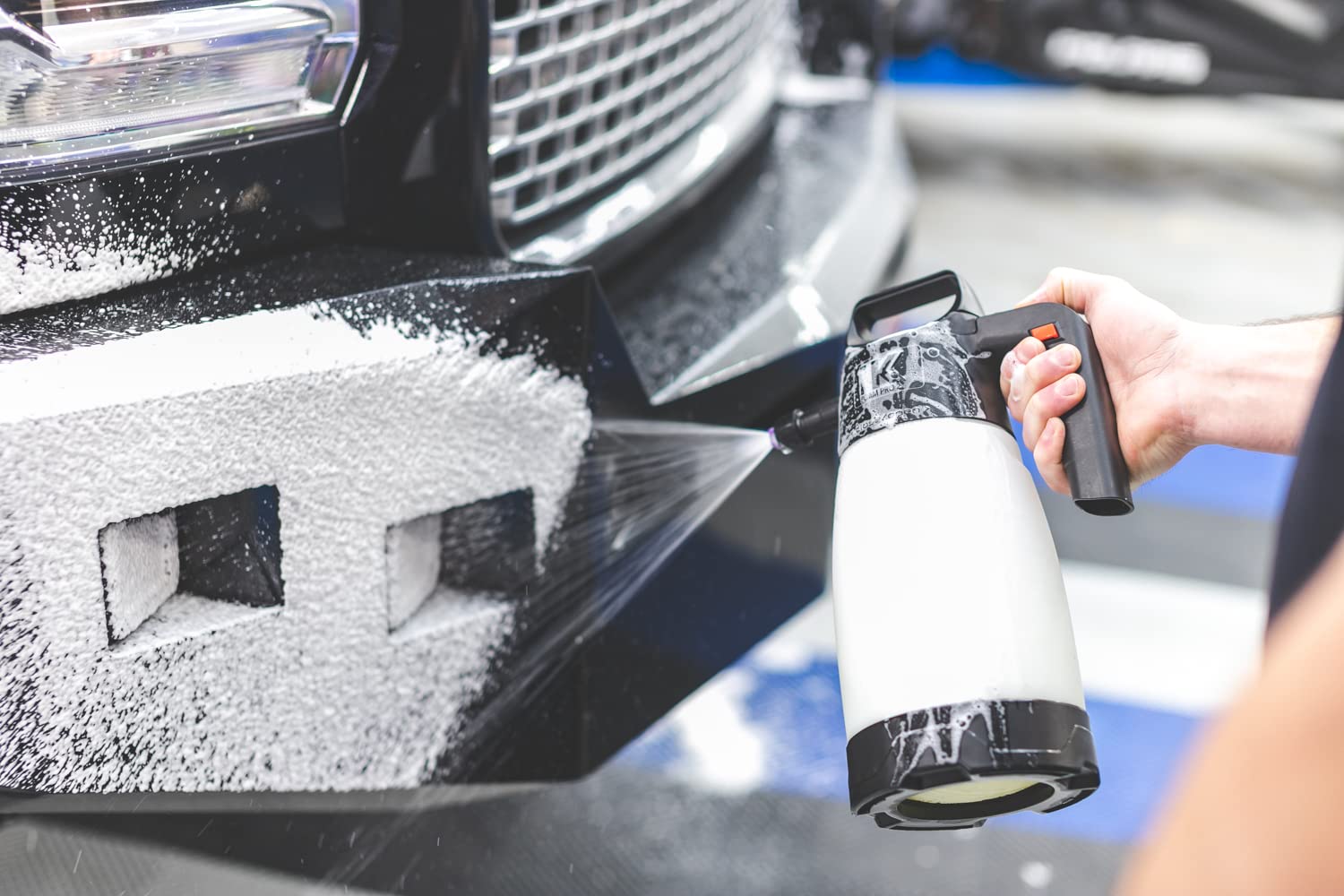 IK FOAM Pro 2+ spraying foam onto car exterior showing effective coverage and cling