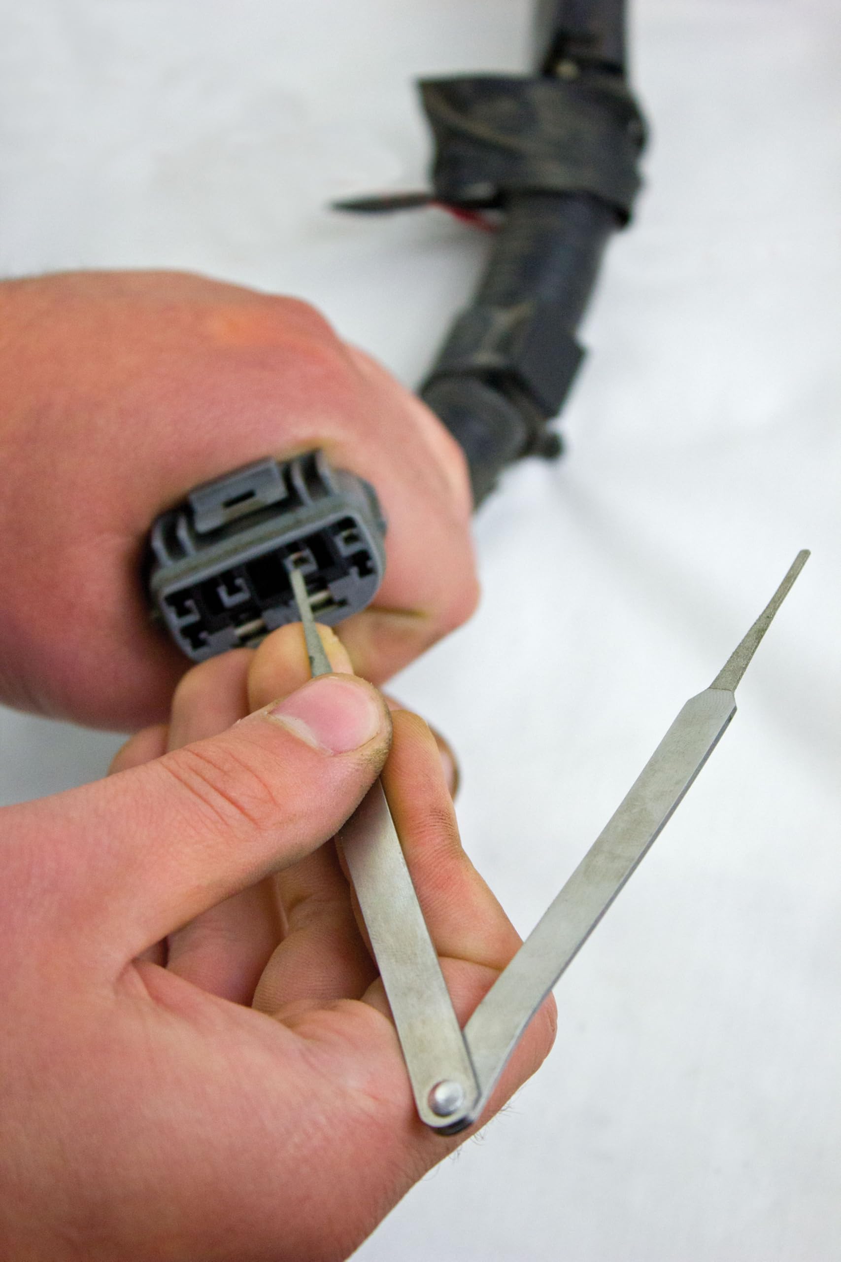 Innovative Products of America tool cleaning a trailer plug terminal to restore connectivity on site