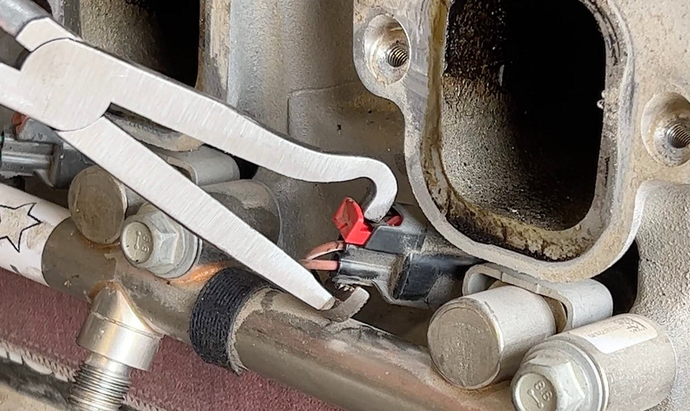 Lisle 37960 pliers in use on car sensor connector demonstrating one-handed disconnect