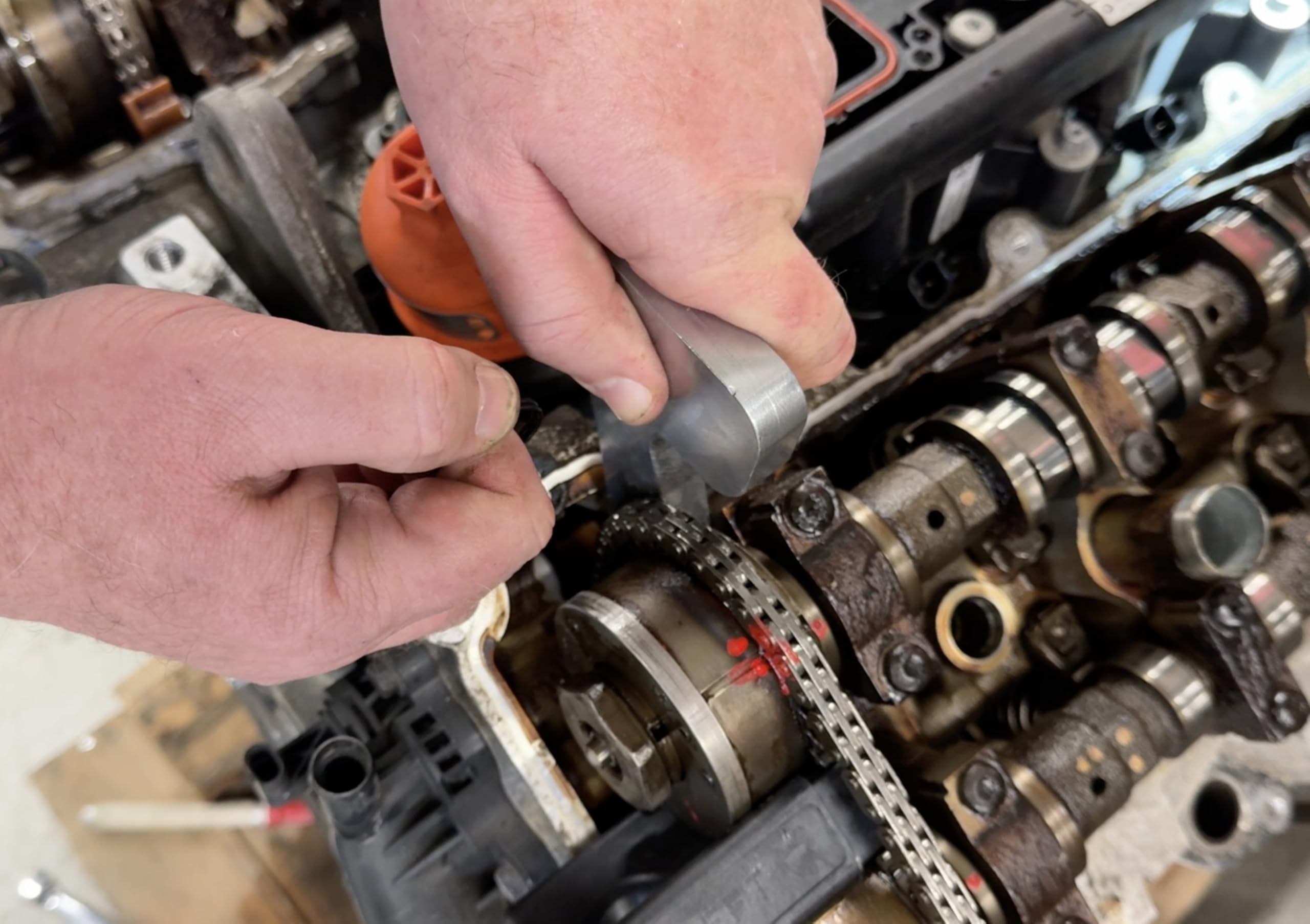 Lisle holding tools in use on a Pentastar engine demonstrating secure phaser locking and tensioner release for safe service