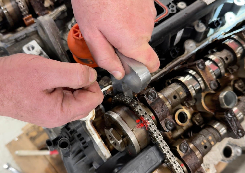 Lisle holding tools in use on a Pentastar engine demonstrating secure phaser locking and tensioner release for safe service