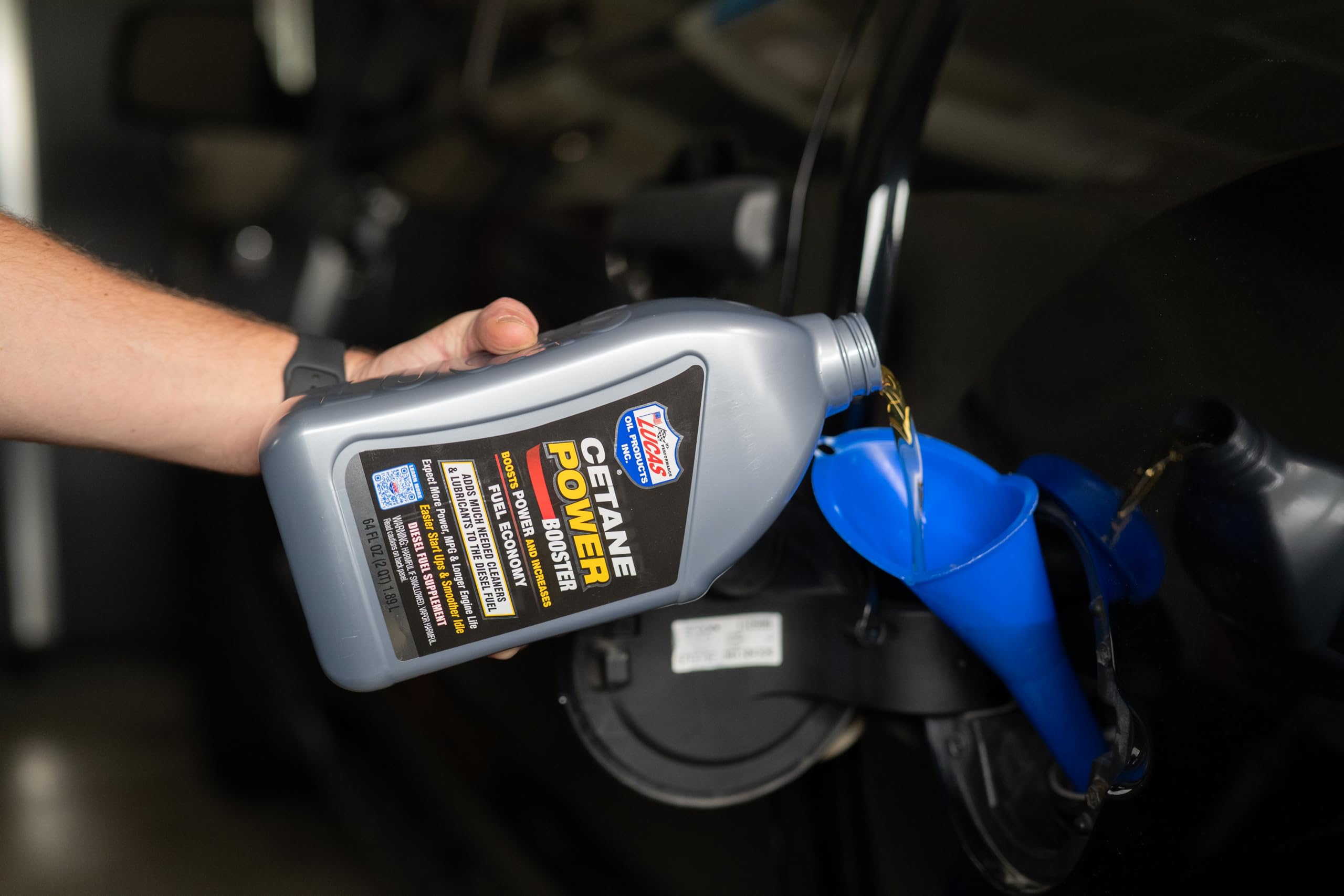 Lucas Oil bottle being added to a truck fuel tank demonstrating performance benefit
