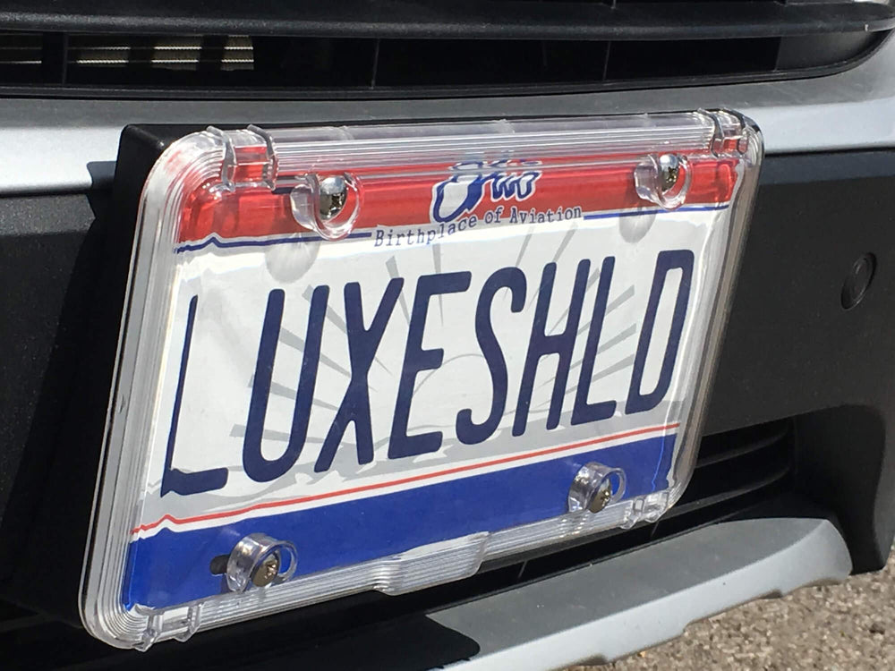 Luxe Shield next to a standard license plate showing precise fit and size