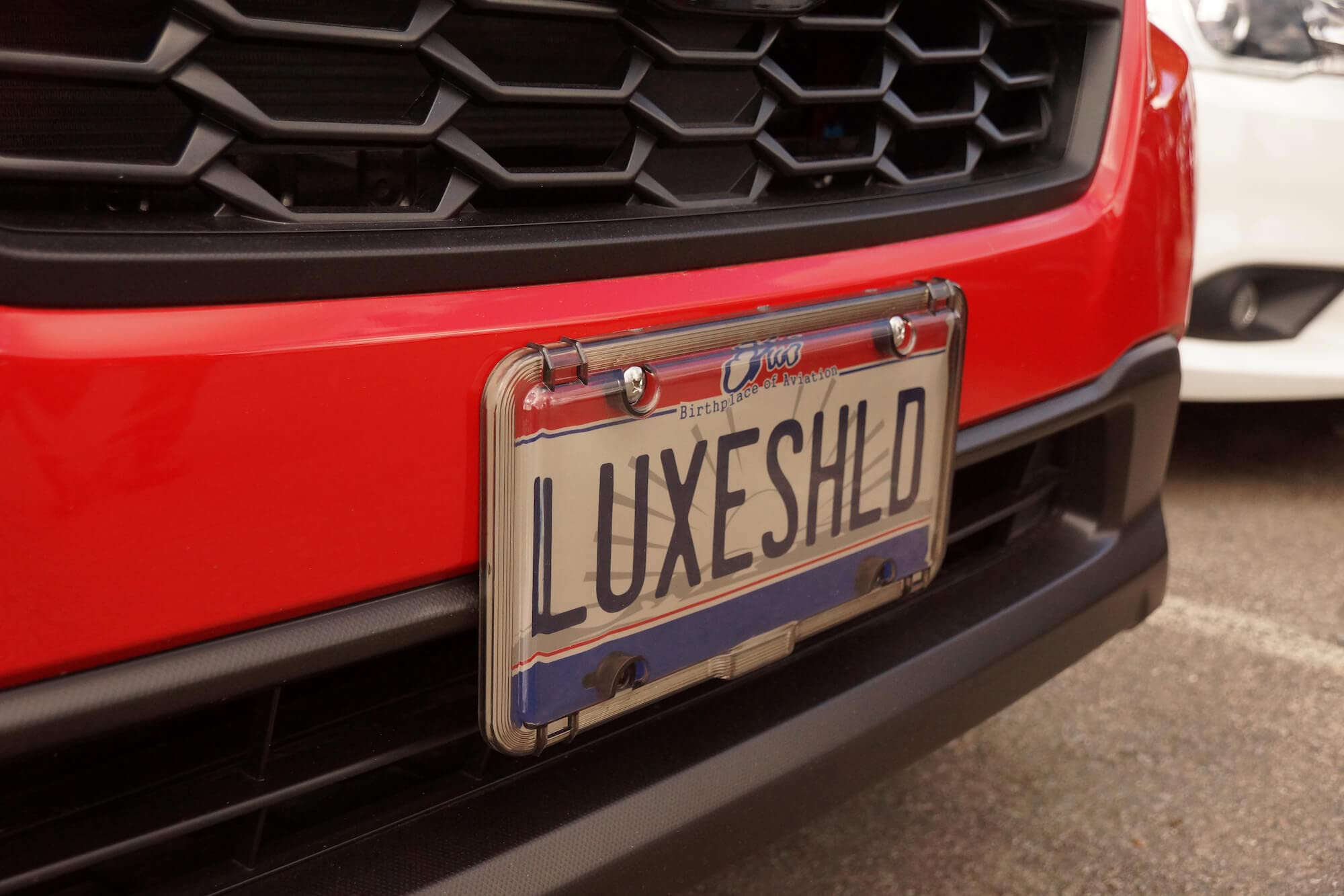 Luxe Shield beside standard plate showing accurate sizing