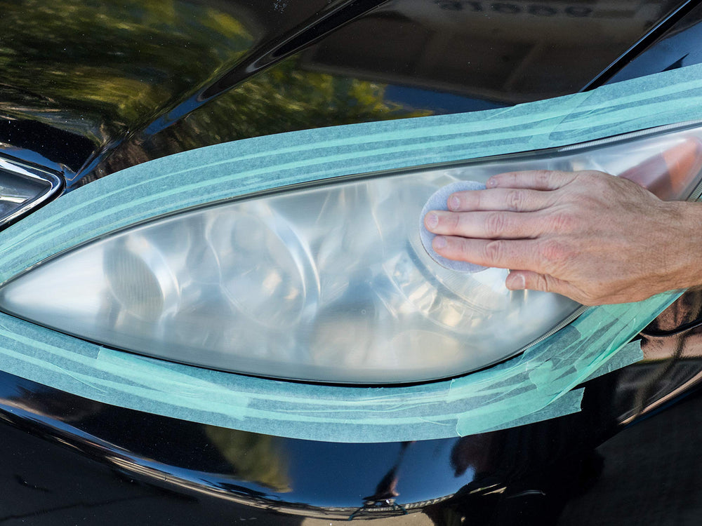 Meguiar's hands using abrasive pad to restore headlight clarity