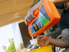 Meguiar's SiO2 boost being poured into a wash bucket for protection