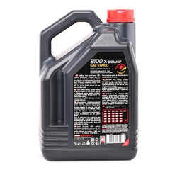 Motul 8100 being poured into an engine bay demonstrating quick cold-start lubrication benefit