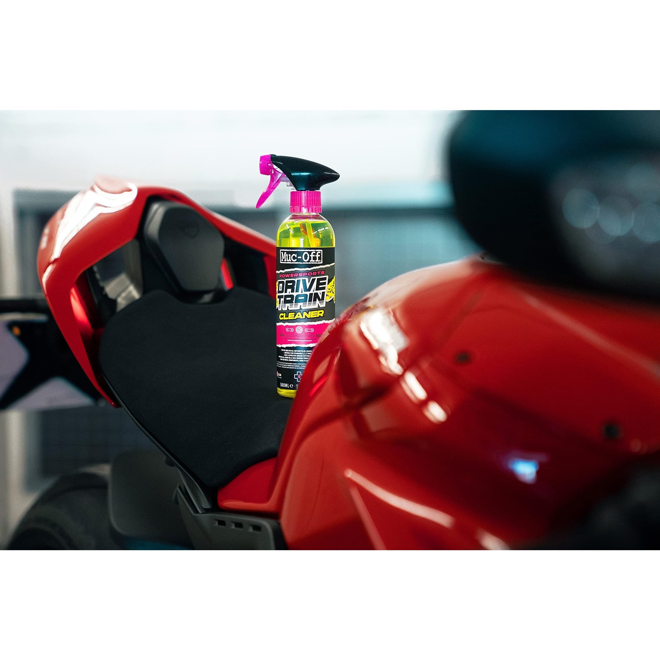 Muc-Off cleaner spraying onto motorcycle chain showing fast grease removal benefit