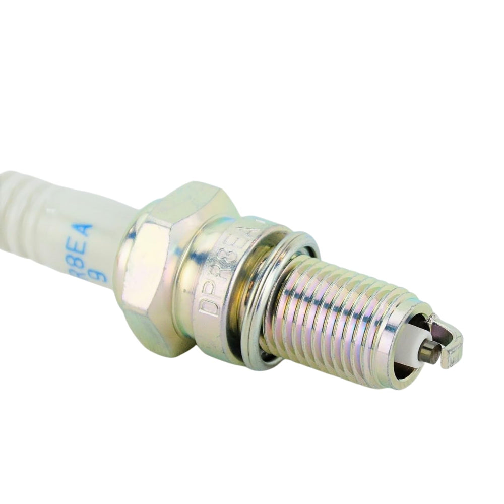 NGK spark plug beside a coin illustrating size and reach for correct application