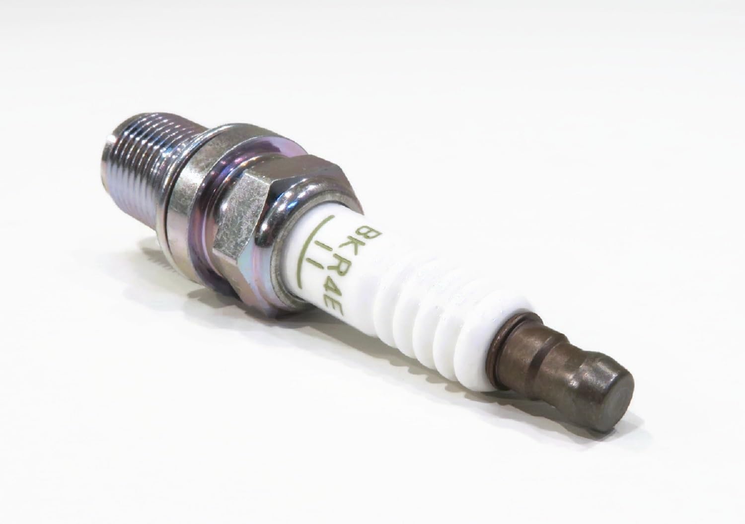 NGK bulk pack open showing four new plugs and cost-saving packaging benefit