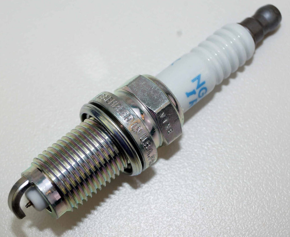NGK spark plug set on bench with tools showing easy installation benefit