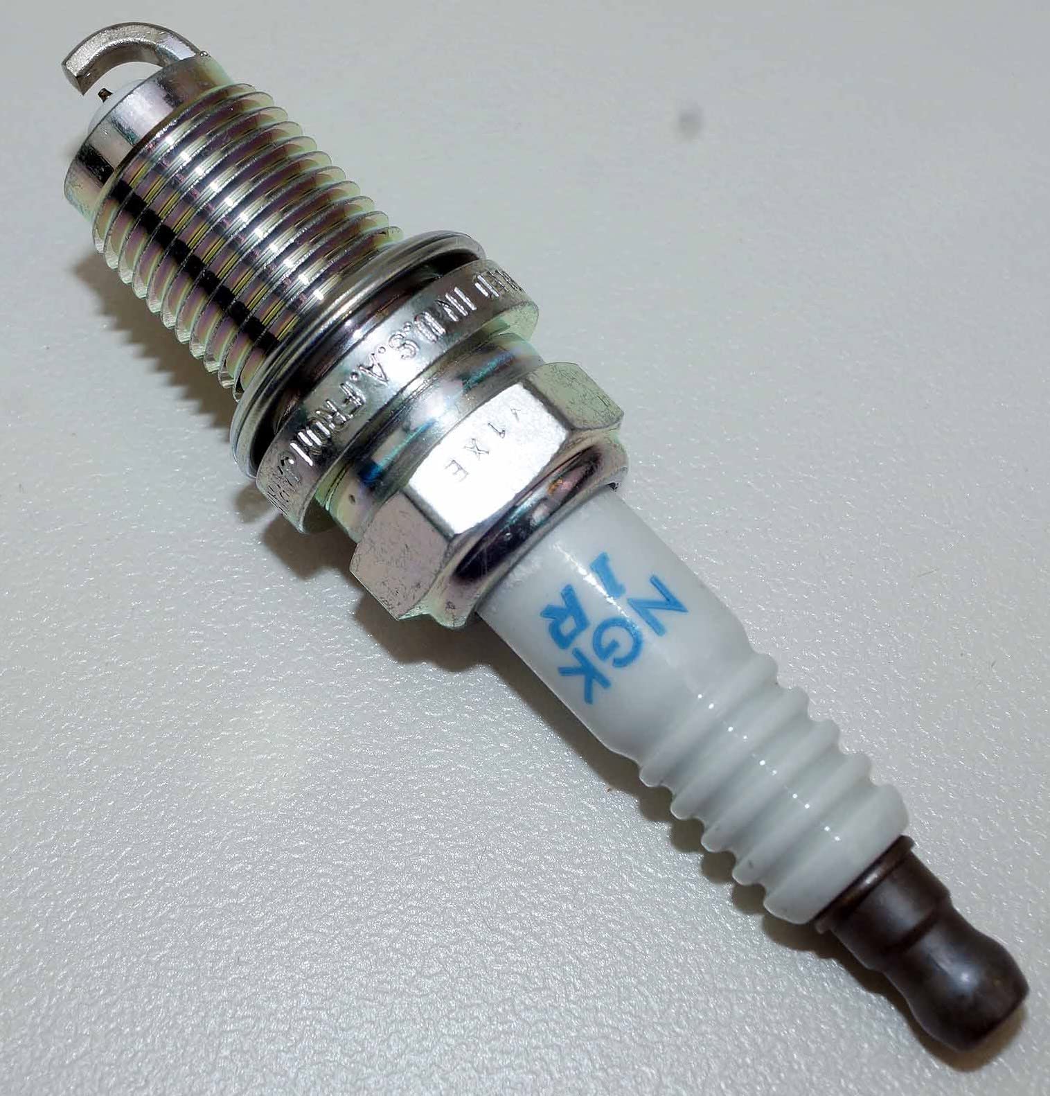 NGK spark plug beside ruler showing size and correct fitment benefit