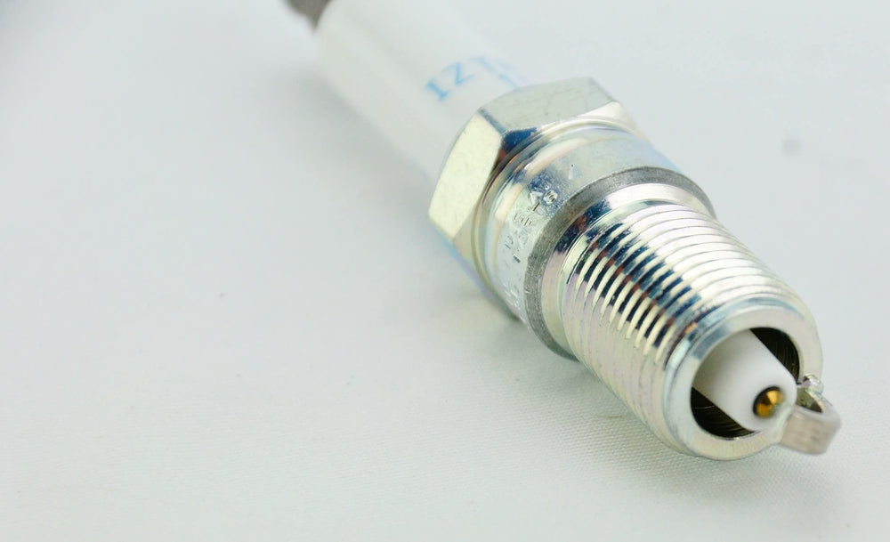 Open NGK pack revealing all eight IZTR5B11 plugs for full-cylinder replacement convenience