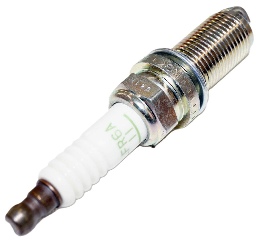NGK spark plug beside ruler for size comparison and fit verification