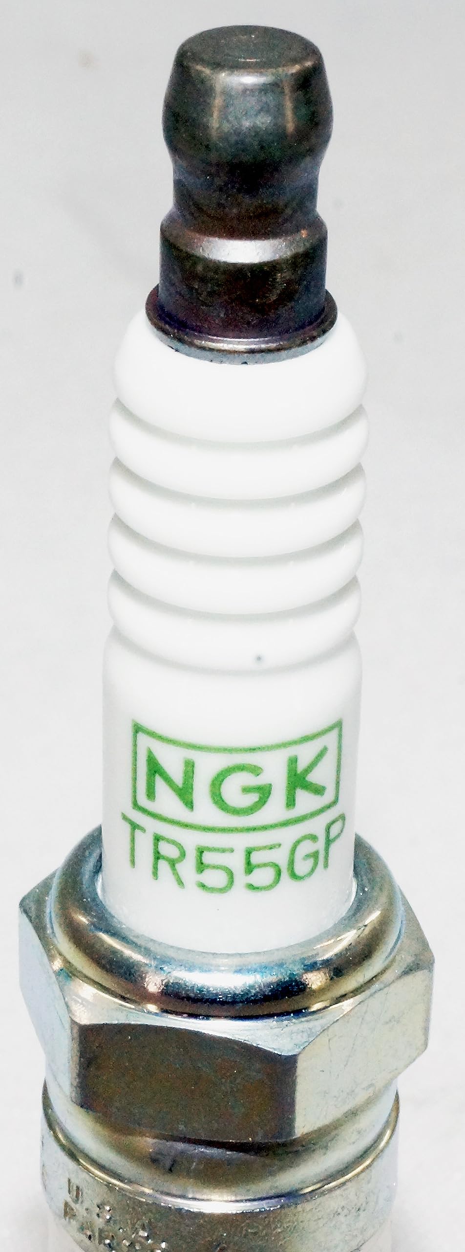 NGK TR55GP next to ruler for scale conveying plug size and compatibility