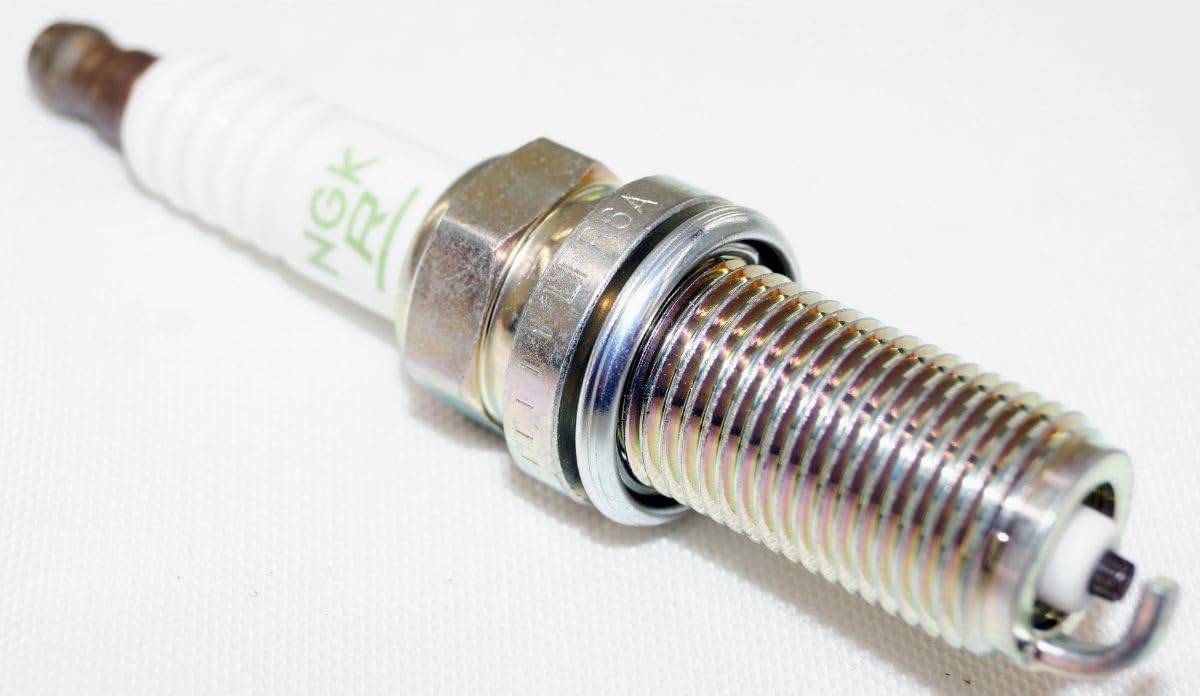 Mechanic in workshop with NGK plugs demonstrating professional use
