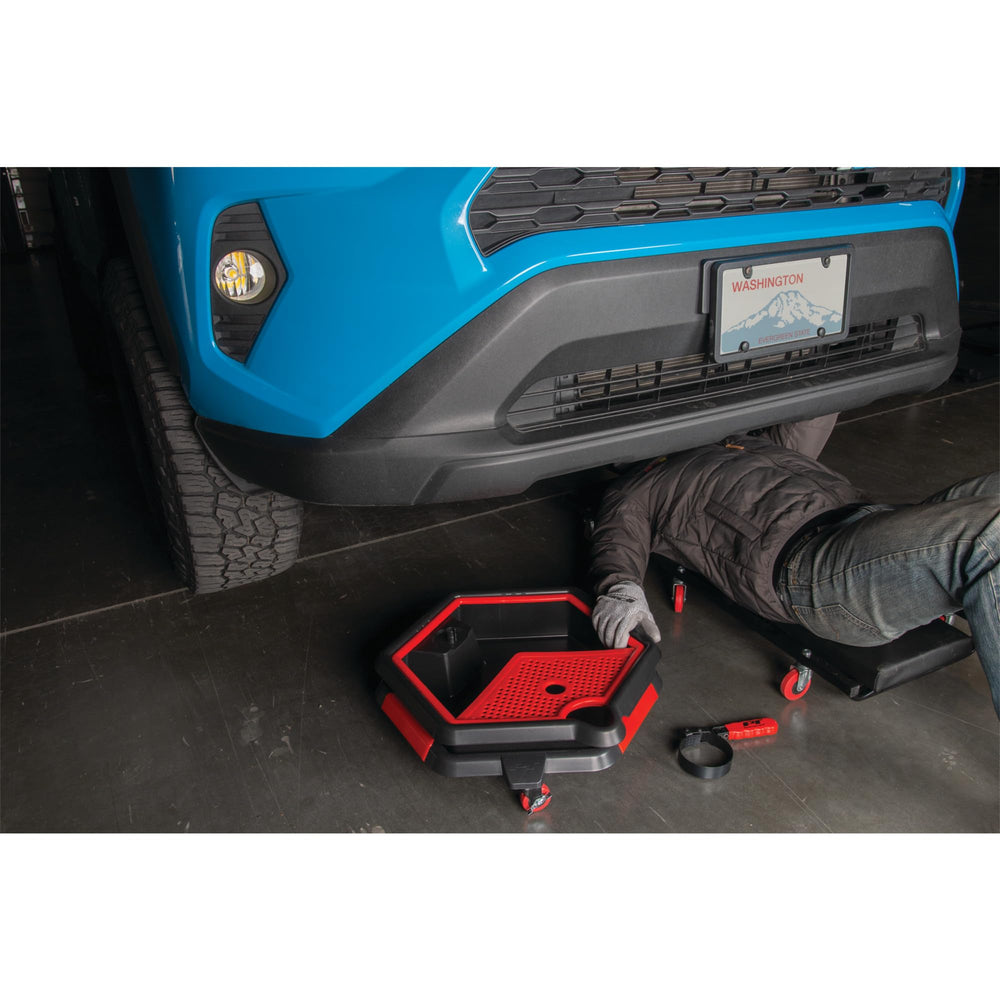 Performance Tool drain pan positioned under a vehicle for oil change