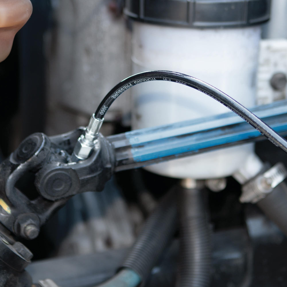 Performance Tool in-use on car suspension demonstrating precise grease application