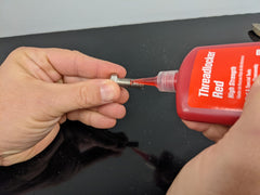 Permatex 27140 being applied to a stud preventing vibration loosening