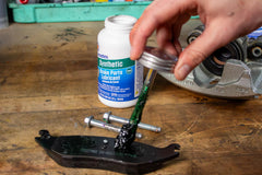 Permatex lubricant applied to a caliper pin ensuring smooth sliding action